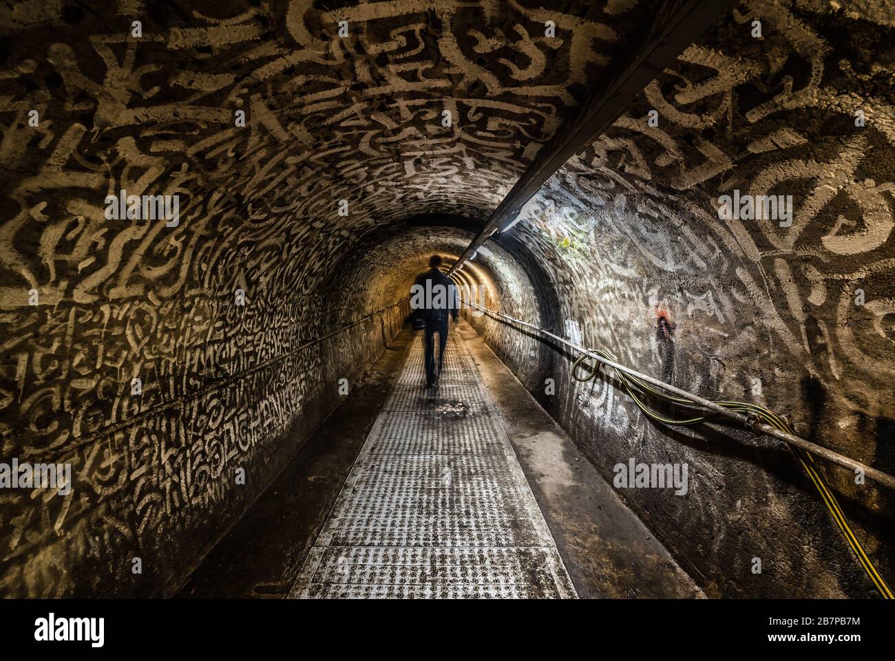 Anderlecht, Brussels / Belgium - 07 16 2019: Man walking in the industrial interiors of the sewer museum main tunnel of the Chaussée de Mons Stock Photo