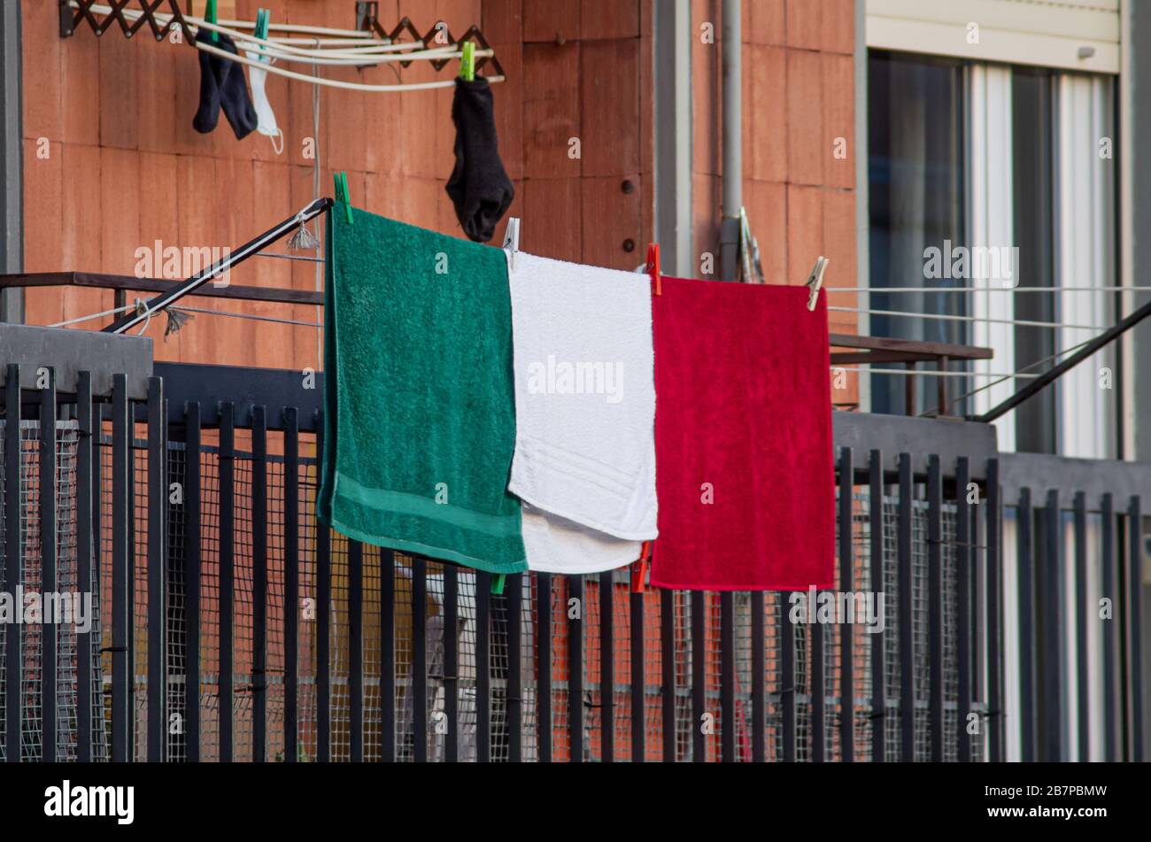 three green, white, red towels arranged like an italian flags hanged from a balcony in Italy during the Coronavirus(COVID-19) nationwide lockdown Stock Photo