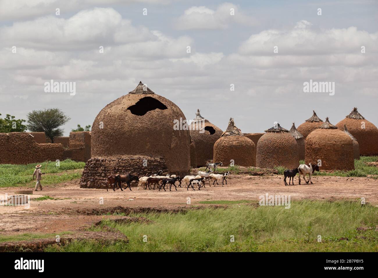 Farmer in Sahel zone western Africa  traditional  mud huts Stock Photo