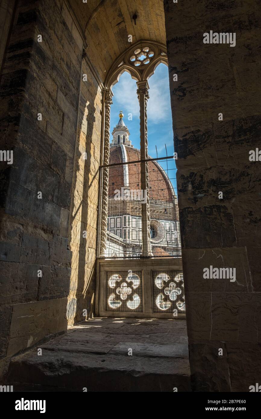Looking through stone archway about halfway up Bell Tower (Campanile) to iconic dome of Florence, Italy Stock Photo