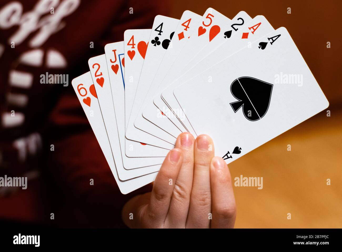 A person holding and showing a set of poker playing cards Stock Photo