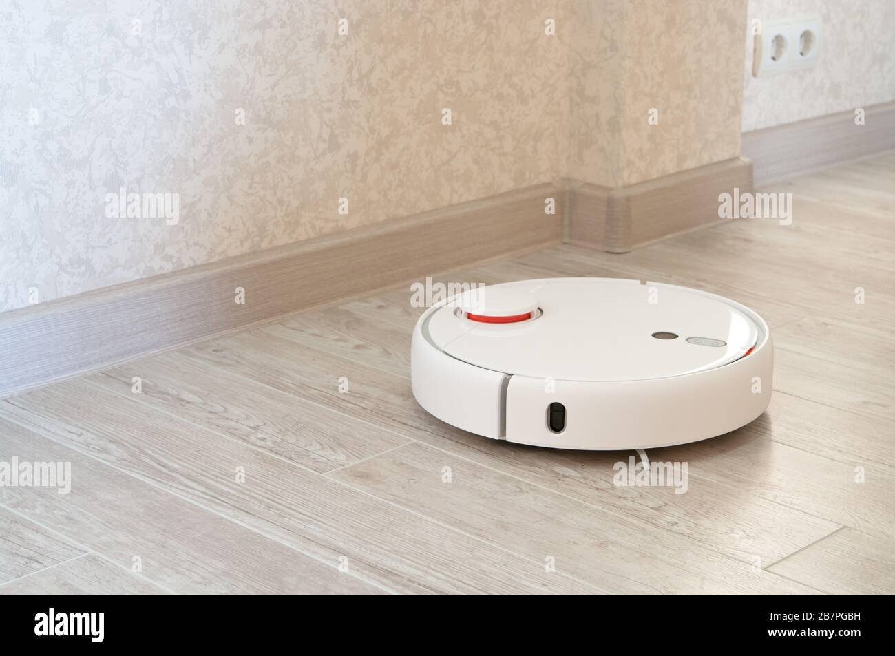 robotic vacuum cleaner on laminate wood floor smart cleaning technology Stock Photo