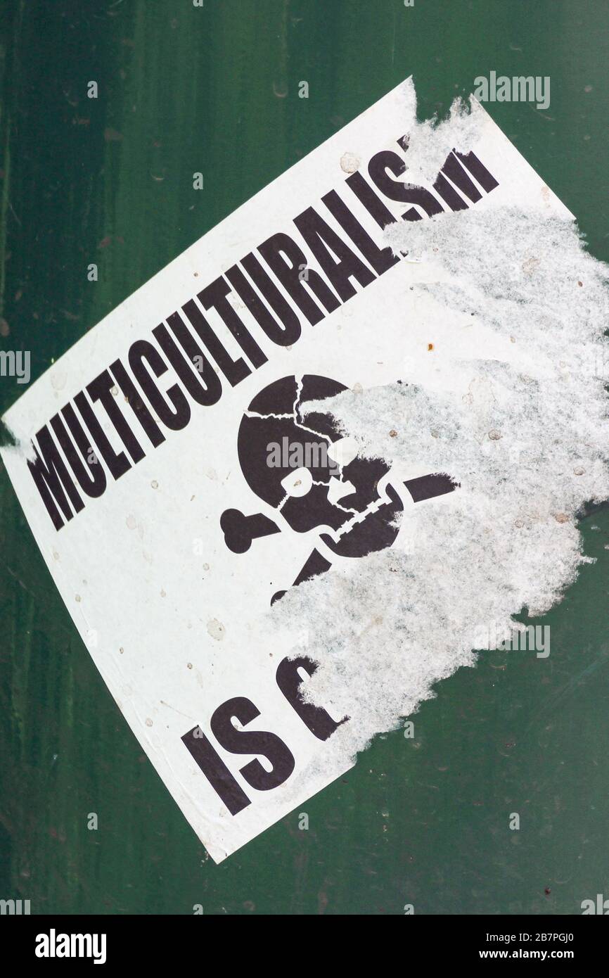 Torn racist sticker against multiculturalism Stock Photo