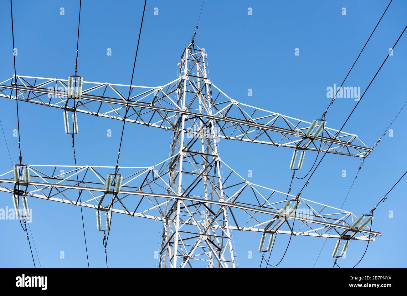 Electricity pylon against a clear blue sky Stock Photo