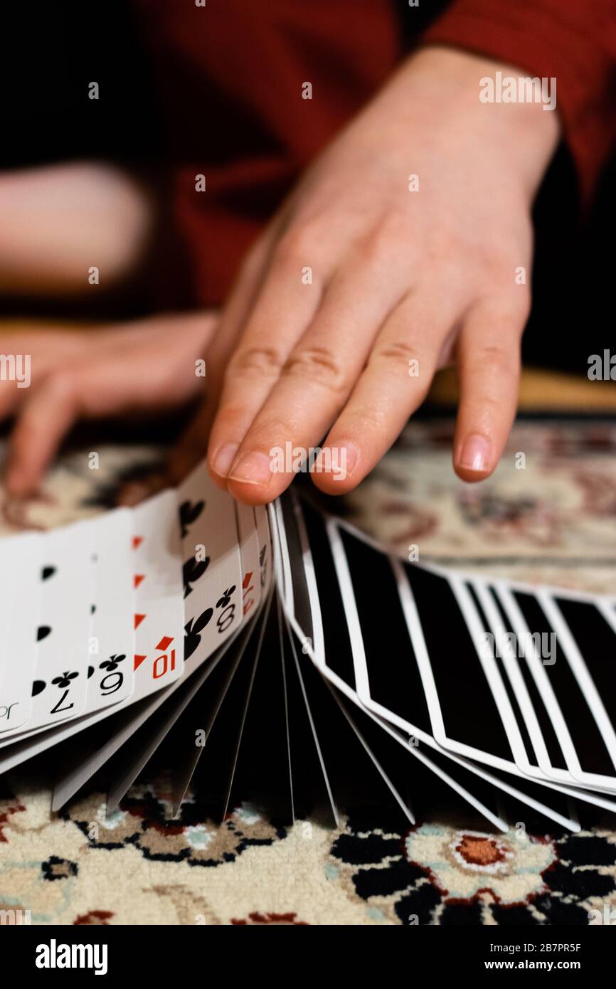 A person doing a ribbon spread with his playing cards Stock Photo