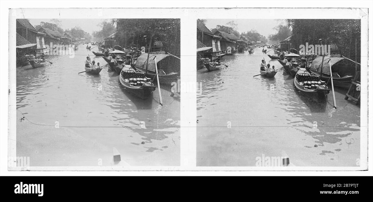 Crowded creek of Stung Sangkae river in the Battambang province  of Cambodia. Local people in their traditional boats and wooden canoes. Stereoscopic photograph from around 1910. Picture on dry glass plate from the Herry W. Schaefer collection. Stock Photo