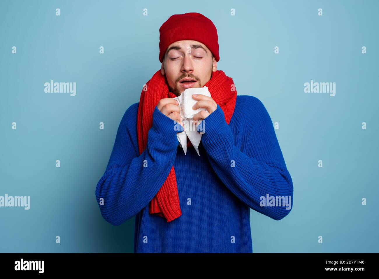 Boy caught a cold and has cold chills. Studio on Cyan background Stock Photo
