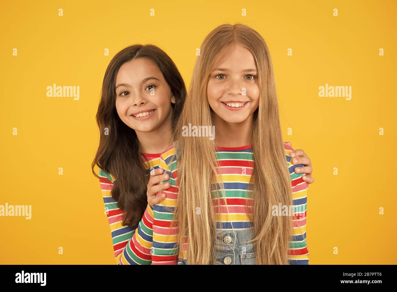 Children are the future. Happy children with long hair yellow background. Small children in casual style. Little children cute smiling. International childrens day. Stock Photo