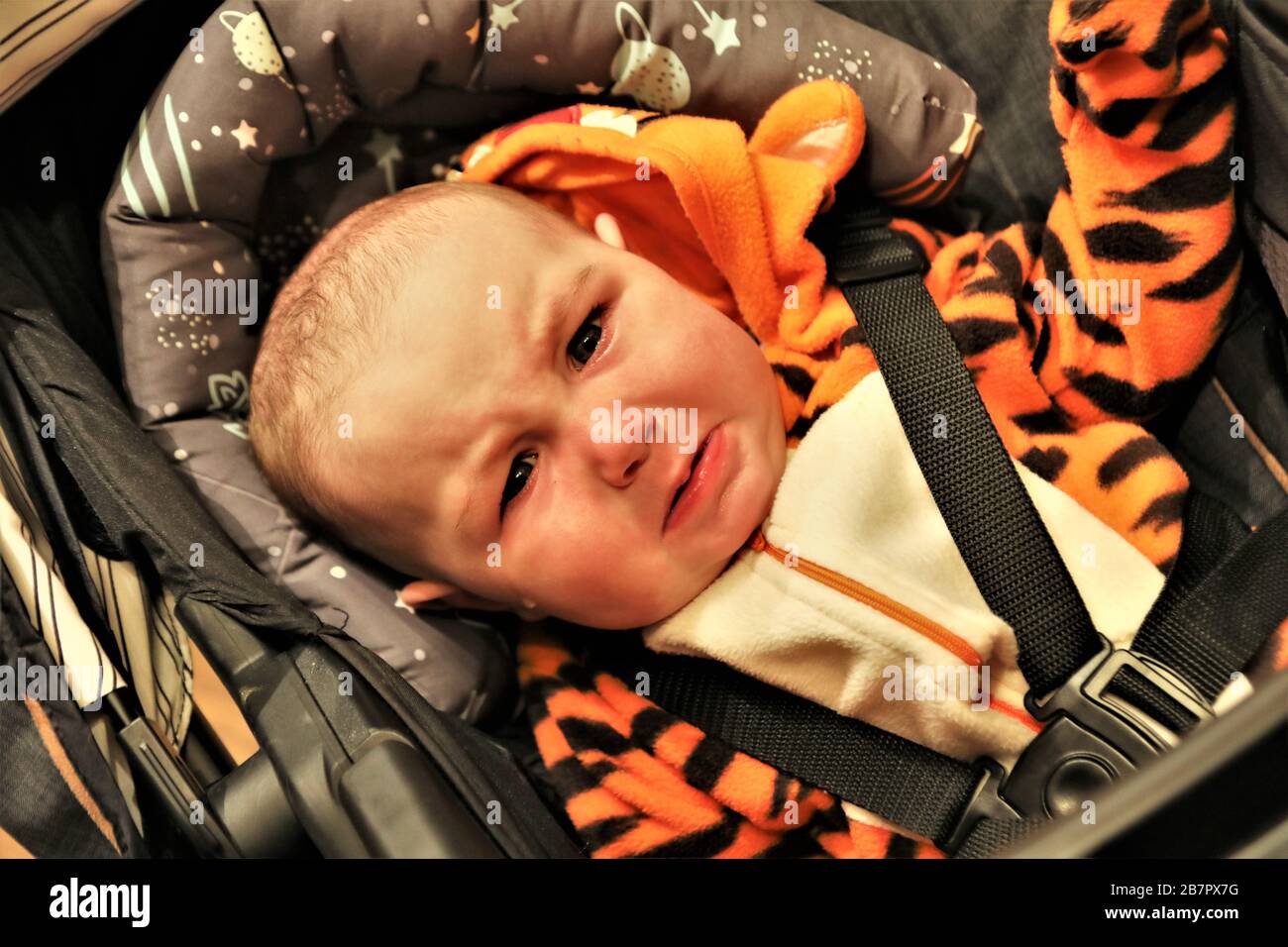 Unhappy baby boy in required California car seat on a family trip Stock Photo