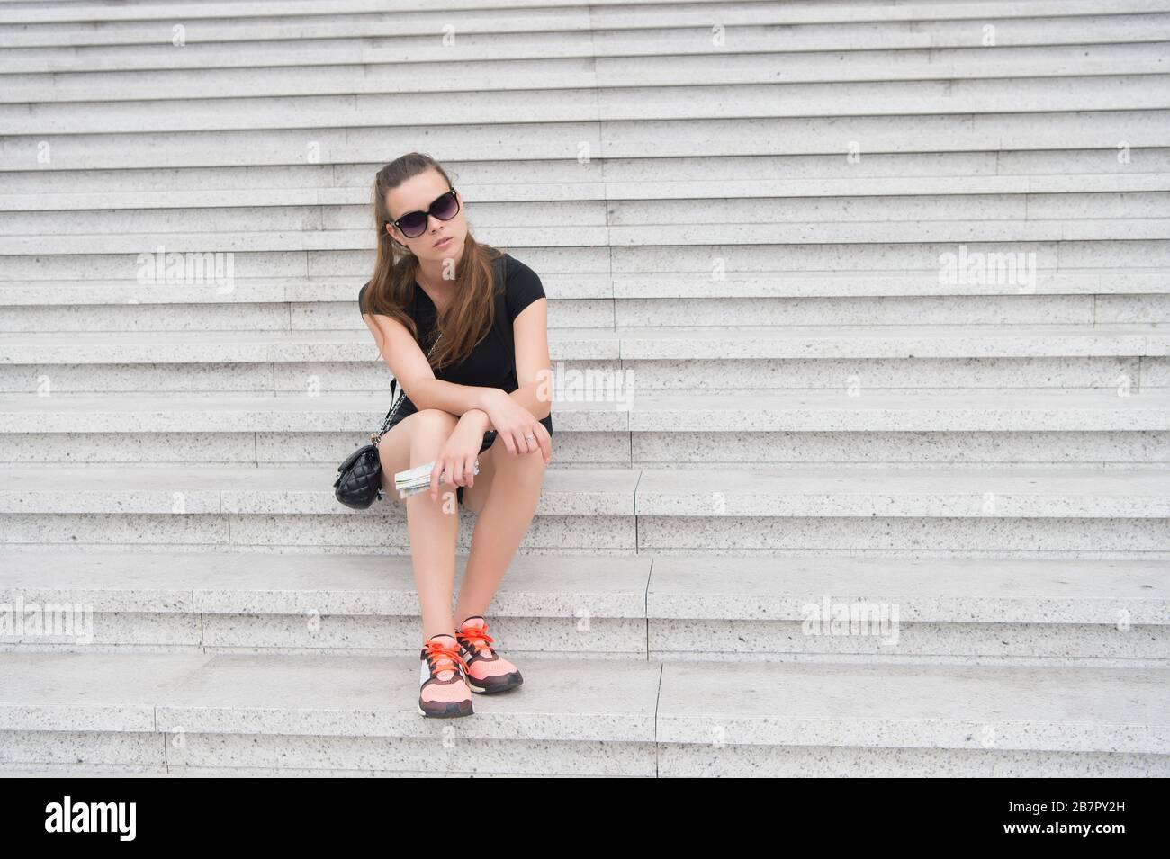 Overcome challenge. Pretty woman sit on stairs. High level of ambition