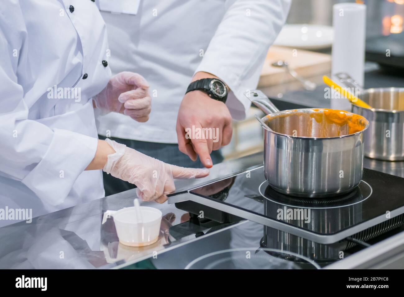 Chef shows how to use electric stove at cuisine of restaurant Stock Photo