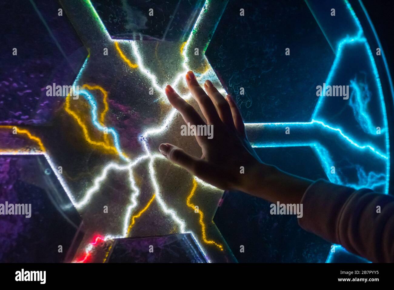 Electricity, science and physics concept - woman touching plasma panel display Stock Photo