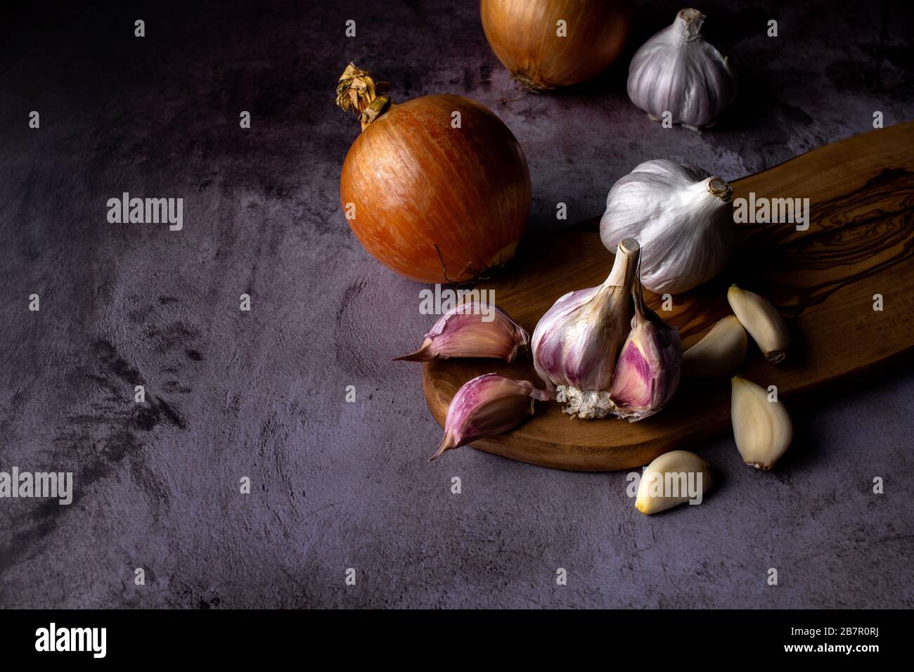 garlic bulb and cloves with onion on dark background Stock Photo - Alamy