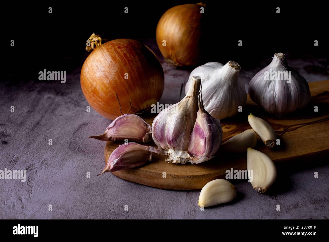 garlic bulb and cloves with onion on dark background Stock Photo - Alamy