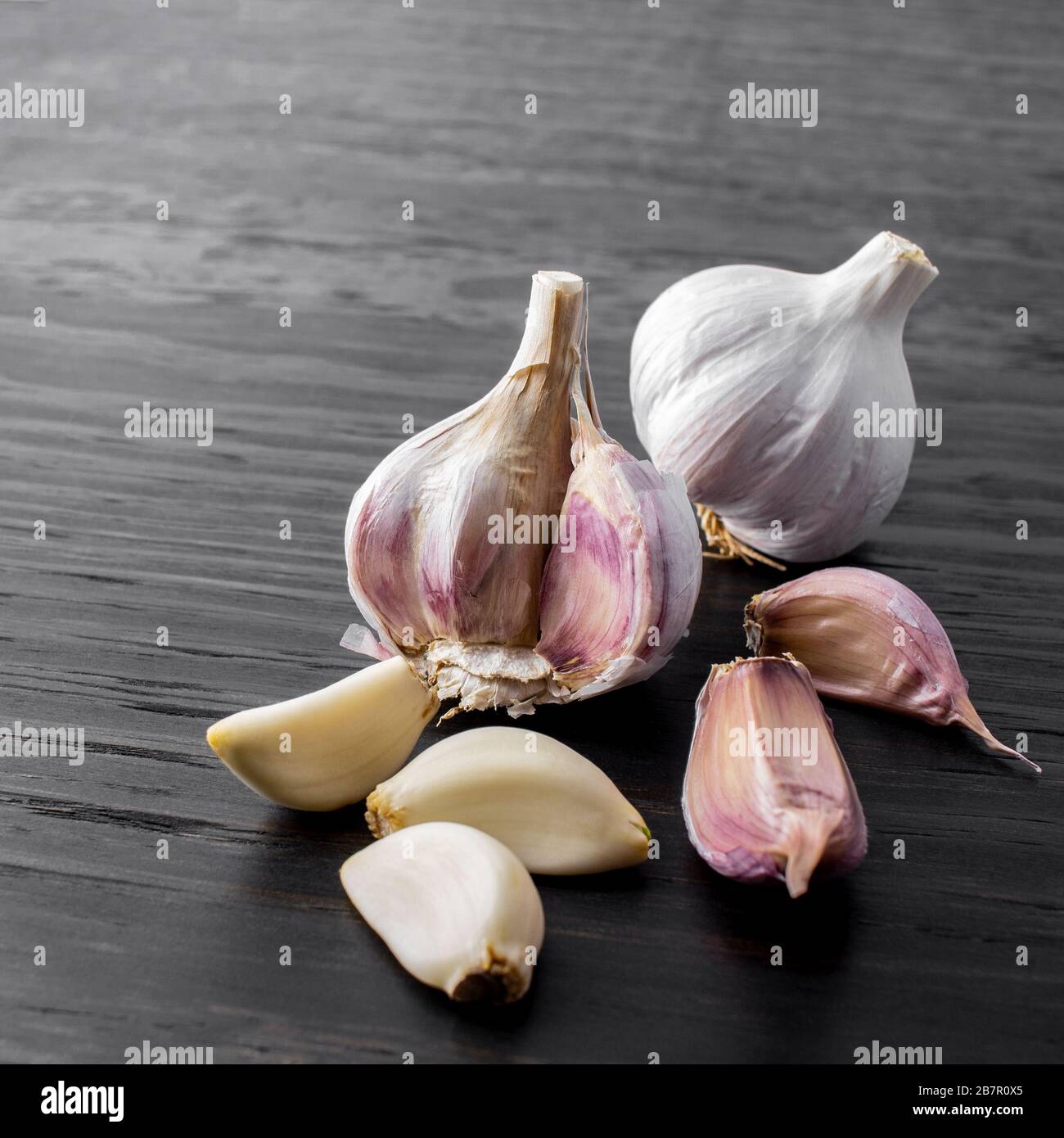 garlic cloves and bulb on wood background Stock Photo - Alamy
