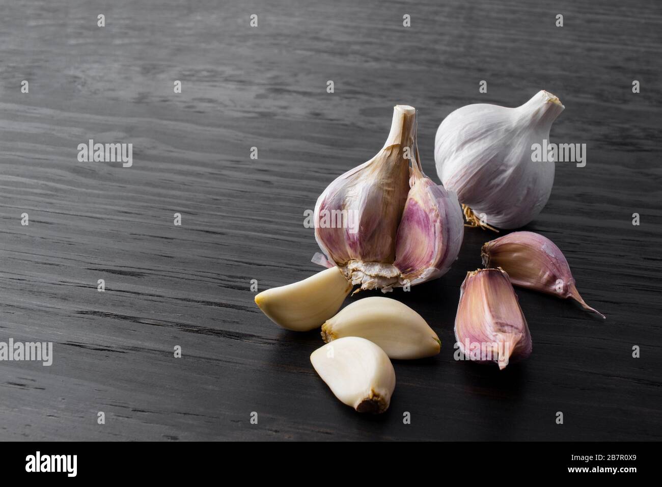 garlic cloves and bulb on wood background Stock Photo - Alamy