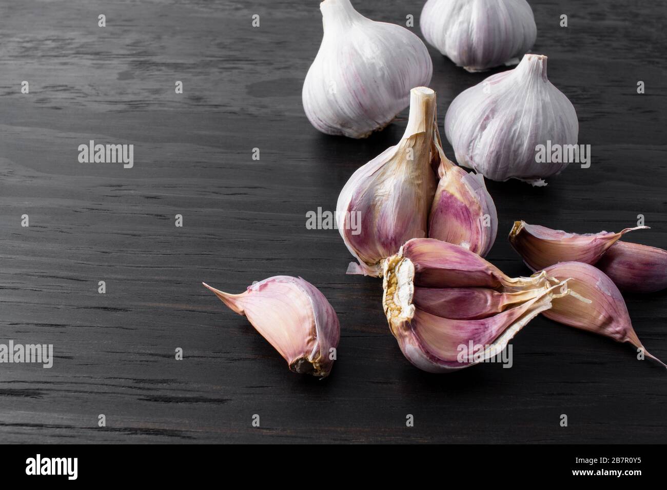 garlic cloves and bulb on wood background Stock Photo Alamy