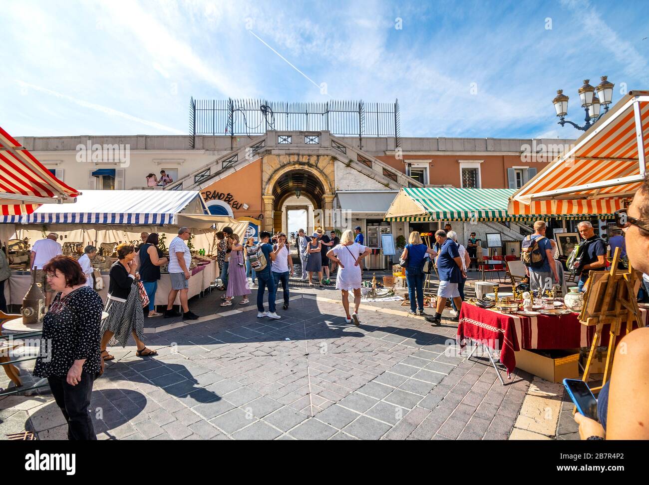 Tourists enjoy a sunny summer morning at the Cours Saleya outdoor market in the Old Town district of Vieux Nice, France, on the French Riviera. Stock Photo