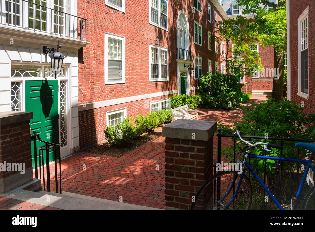 Red brick college dormitory with a bicycle and trees. Stock Photo