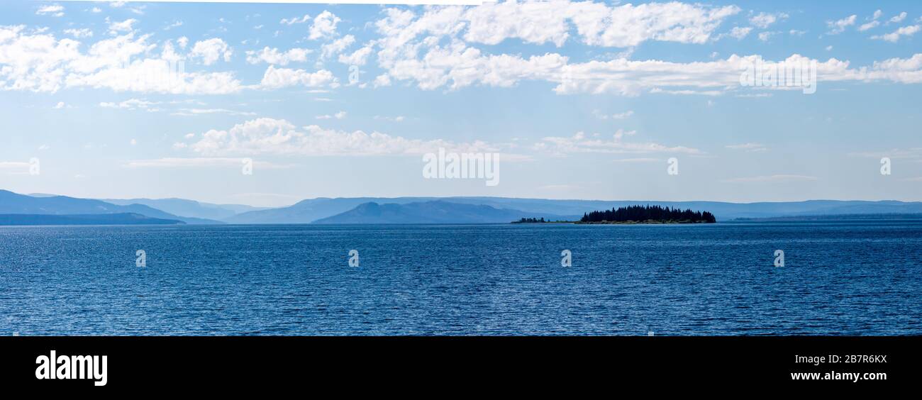 Yellowstone Lake with an island in front of mountains in Yellowstone National Park in August, Panoramic Stock Photo