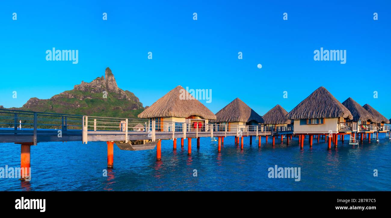 Overwater bungalows with the moon  in Bara Bora Bora, French Polynesia Stock Photo