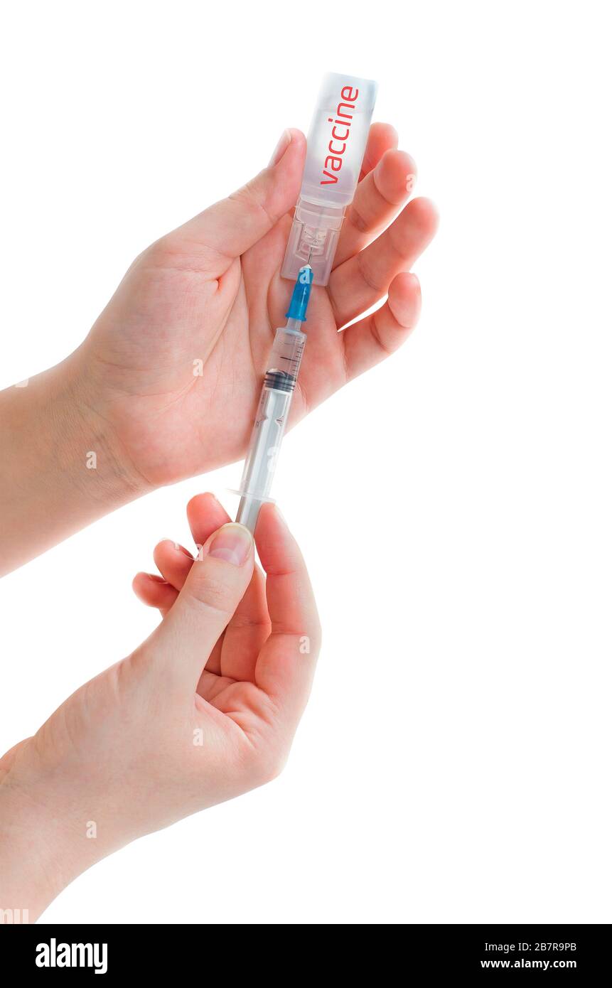 Ampoule with vaccine from a new coronavirus and syringe in a woman hand isolated on white background. Flu vaccination concept. COVID-19. 2019 Novel Co Stock Photo