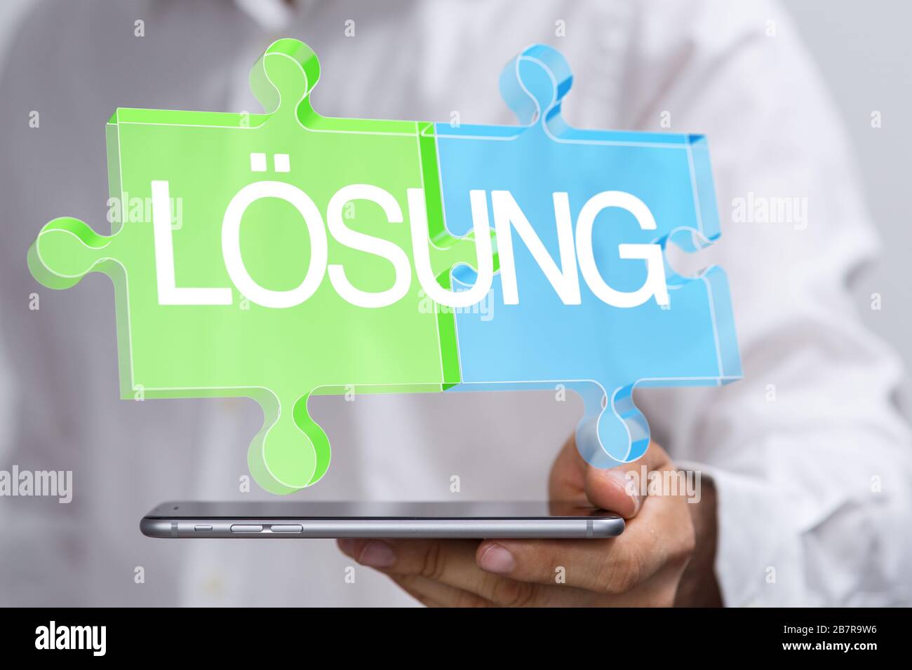 Person presenting the virtual projection of "solution" written on puzzle pieces in German Stock Photo