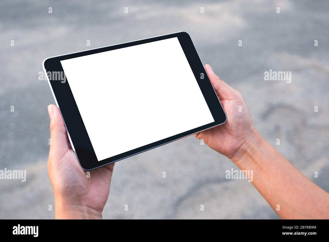 Mockup image of hands holding black tablet pc with blank white screen ...