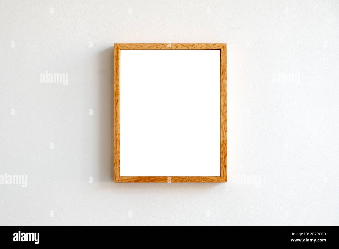 A blank wooden picture frame on white wall background Stock Photo - Alamy