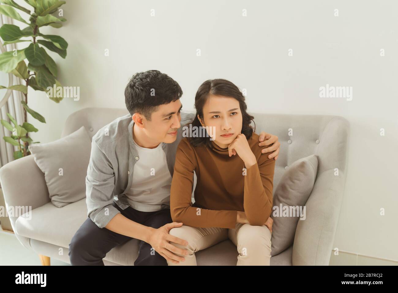 Young asian couple quarreling at home, woman offended. Family relationship difficulties concept, copy space Stock Photo