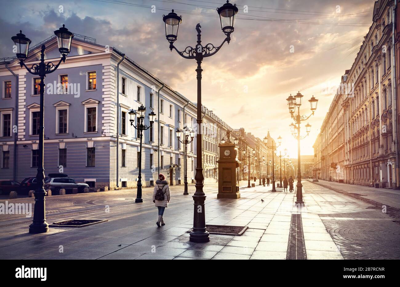 Woman in white jacket walking Malaya Konyushennaya  street with Lanterns and ol buildings in Saint Petersburg Stock Photo