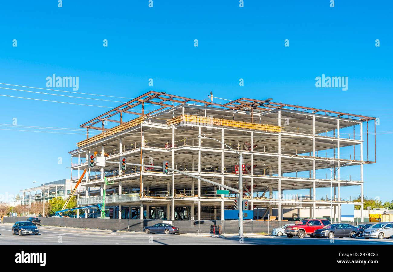 Construction site on a street corner with cars and blue sky Stock Photo