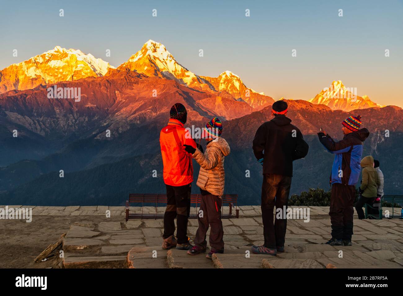 People enjoyying Majestic view of Annapurna south, himchuli and Fishtail mountain during sunset Stock Photo