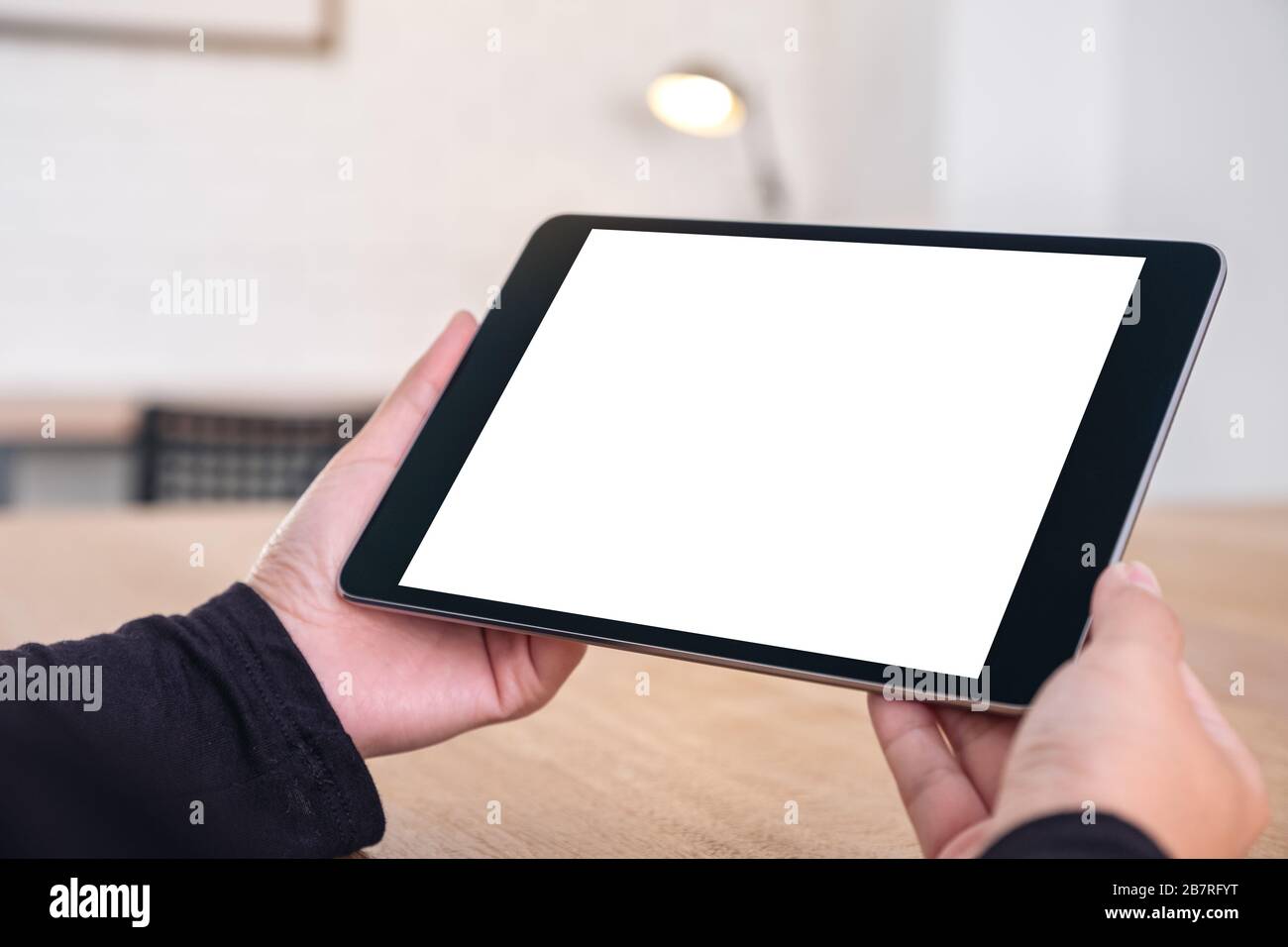 Mockup image of hands holding black tablet pc with blank white screen ...