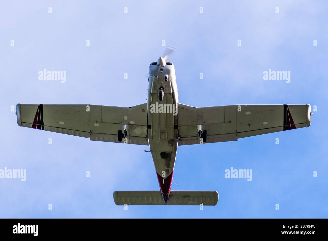 Undercarriage view of flying private airplane Stock Photo