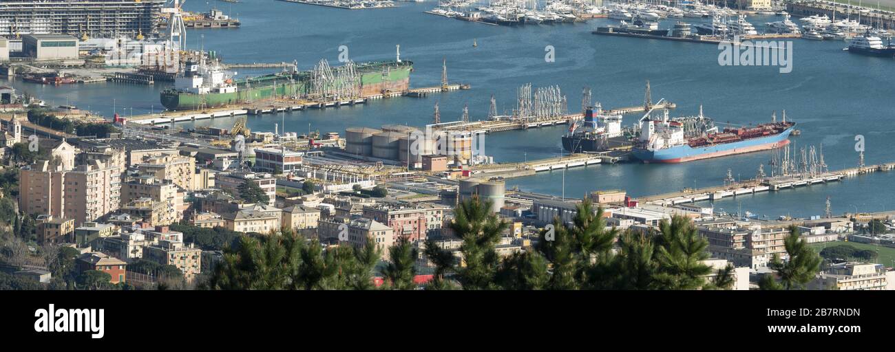 Genoa Italy_March 14, 2020:  Oil port next to the buildings of the city, with large tanks and three chemical tankers moored Stock Photo
