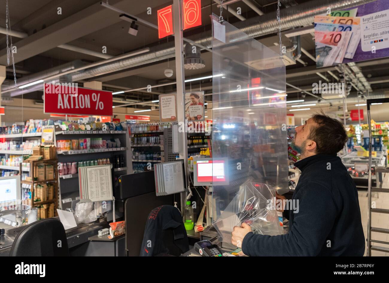 Dresden, Germany. 18th Mar, 2020. In the fight against the spread of the novel coronavirus, an employee in a supermarket installs a Plexiglas panel at the checkout. Credit: Robert Michael/dpa-Zentralbild/dpa/Alamy Live News Stock Photo