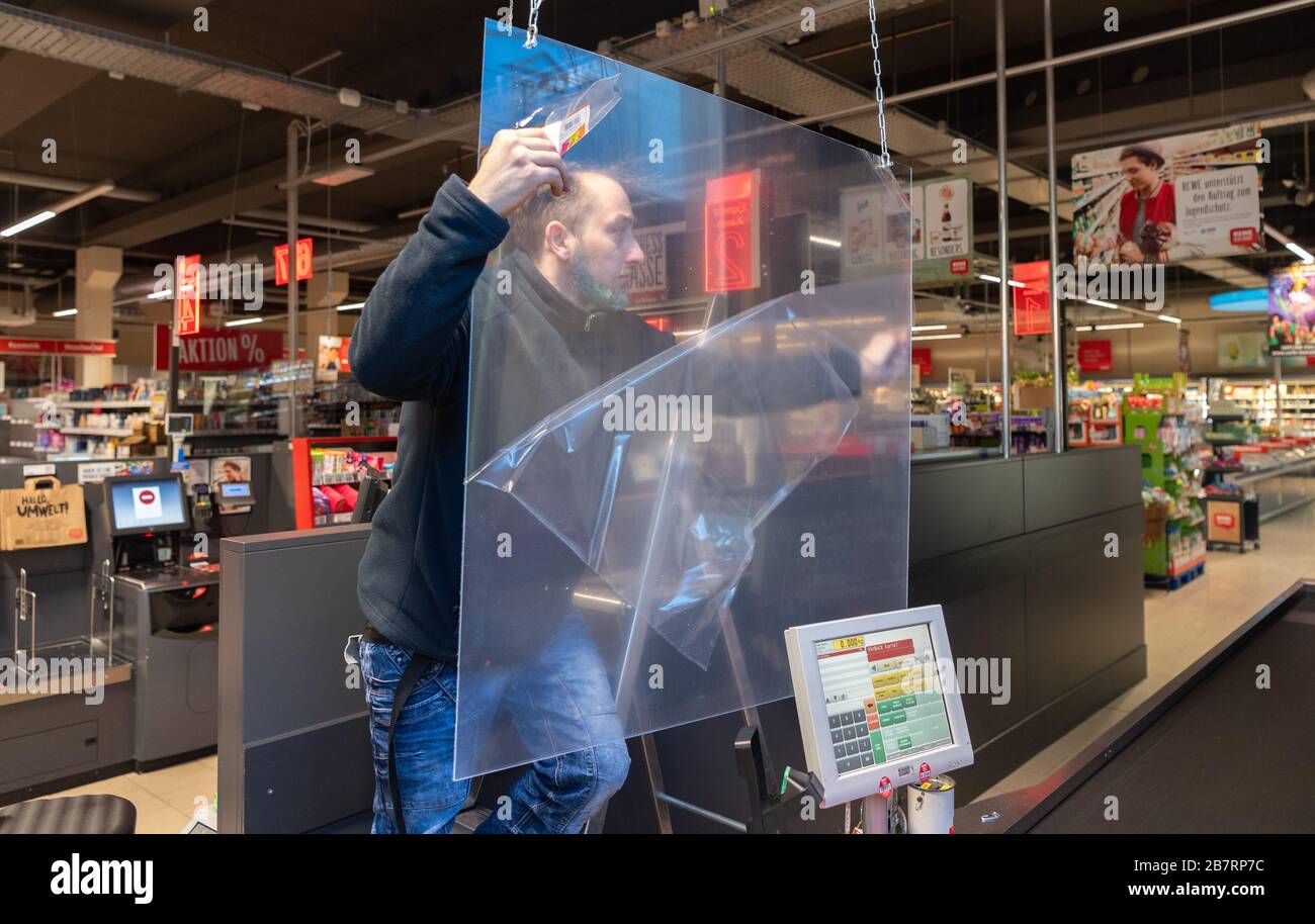 Dresden, Germany. 18th Mar, 2020. In the fight against the spread of the novel coronavirus, an employee in a supermarket installs a Plexiglas panel at the checkout. Credit: Robert Michael/dpa-Zentralbild/dpa/Alamy Live News Stock Photo