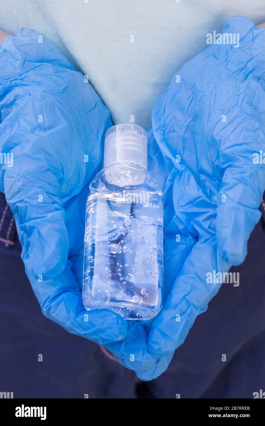 bottle with antibacterial gel in the hands in protective gloves Stock Photo