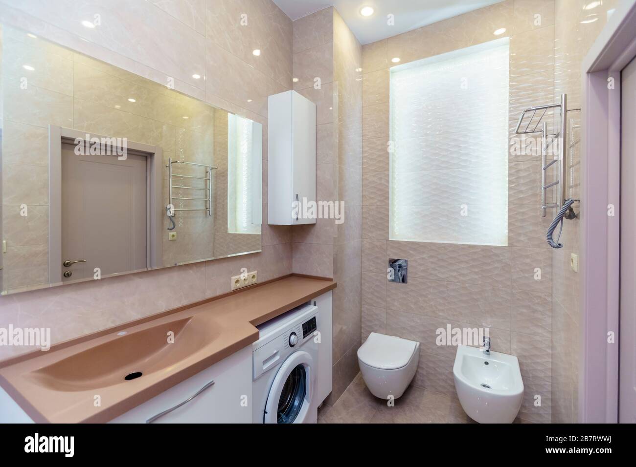Bathroom With Brown Washbasin And Countertop White Cabinets Large Mirror Washing Machine Toilet Beige Wall Tiles Stock Photo Alamy