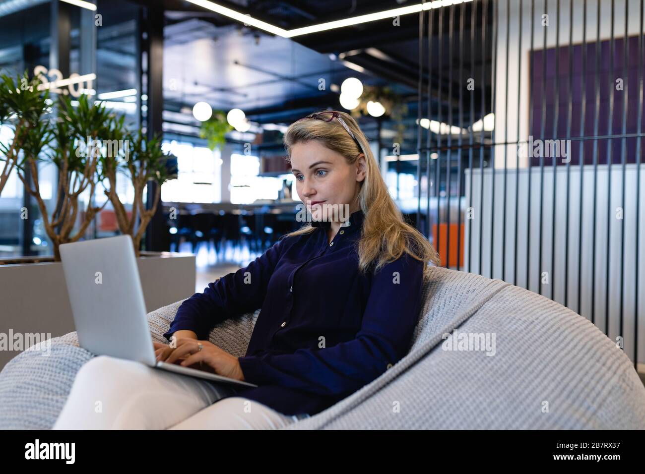 Caucasian woman using a laptop in a bean bag Stock Photo - Alamy