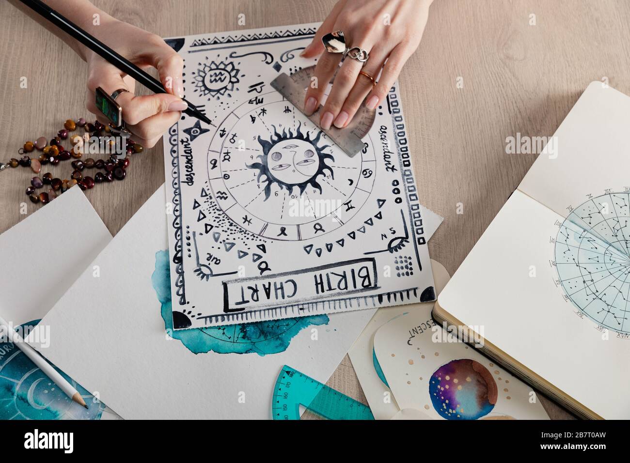 High angle view of watercolor paintings with zodiac signs on cards and