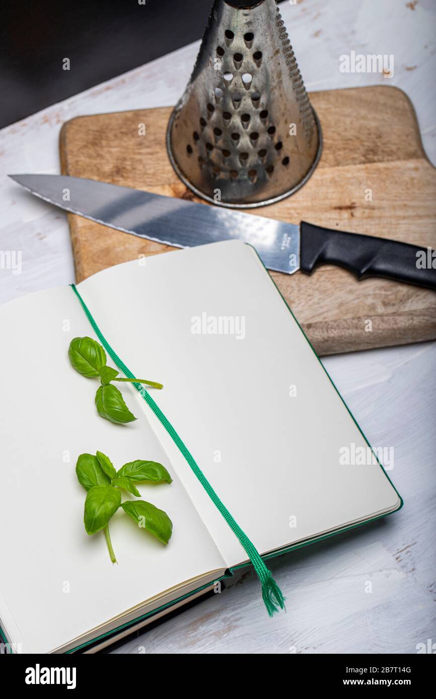 Basil leaveson a desk with a notebook for recipes and notes a composition with negative space a background for advertsing Stock Photo