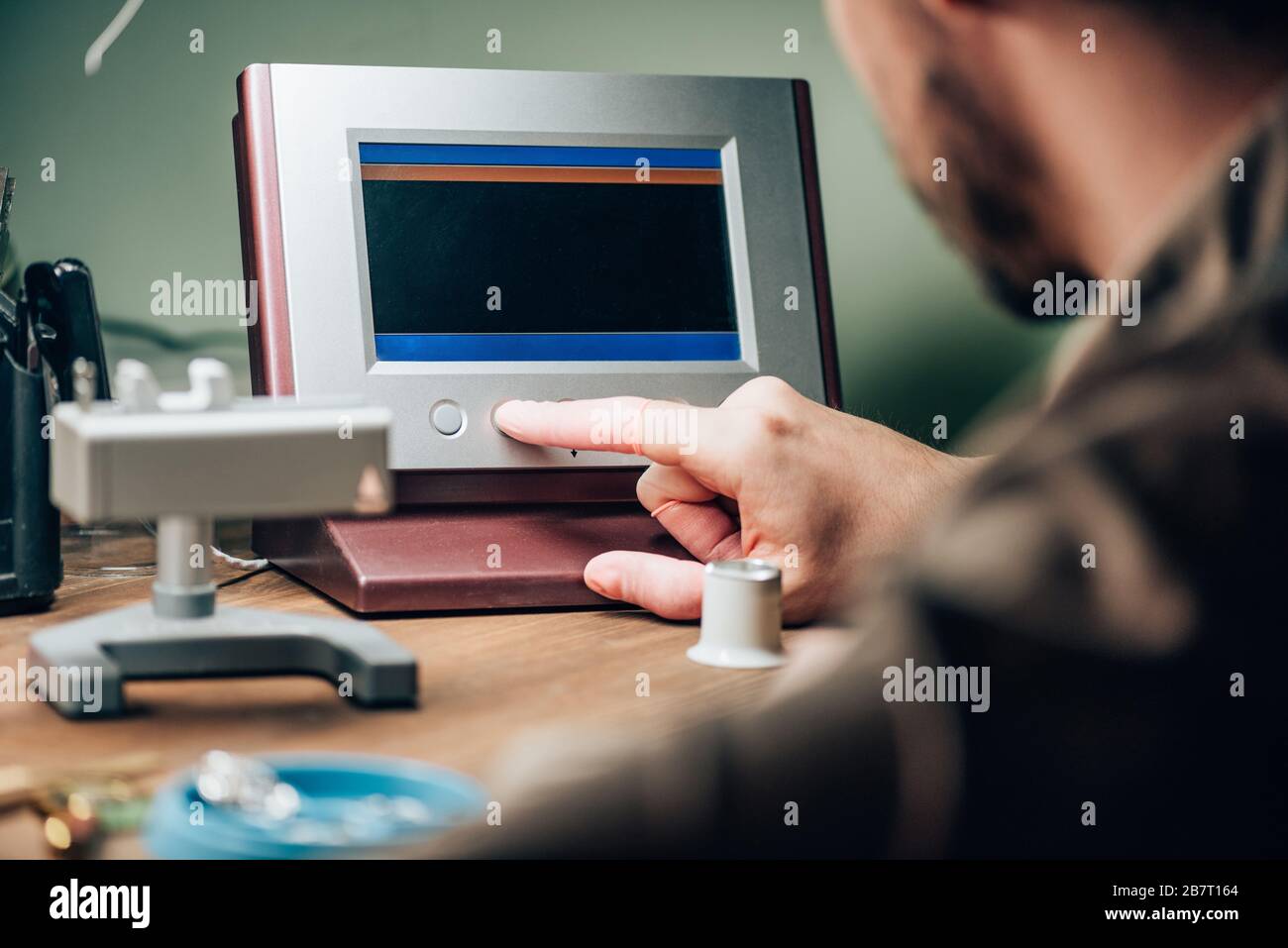 Selective focus of clockmaker working with watch tester at table Stock Photo
