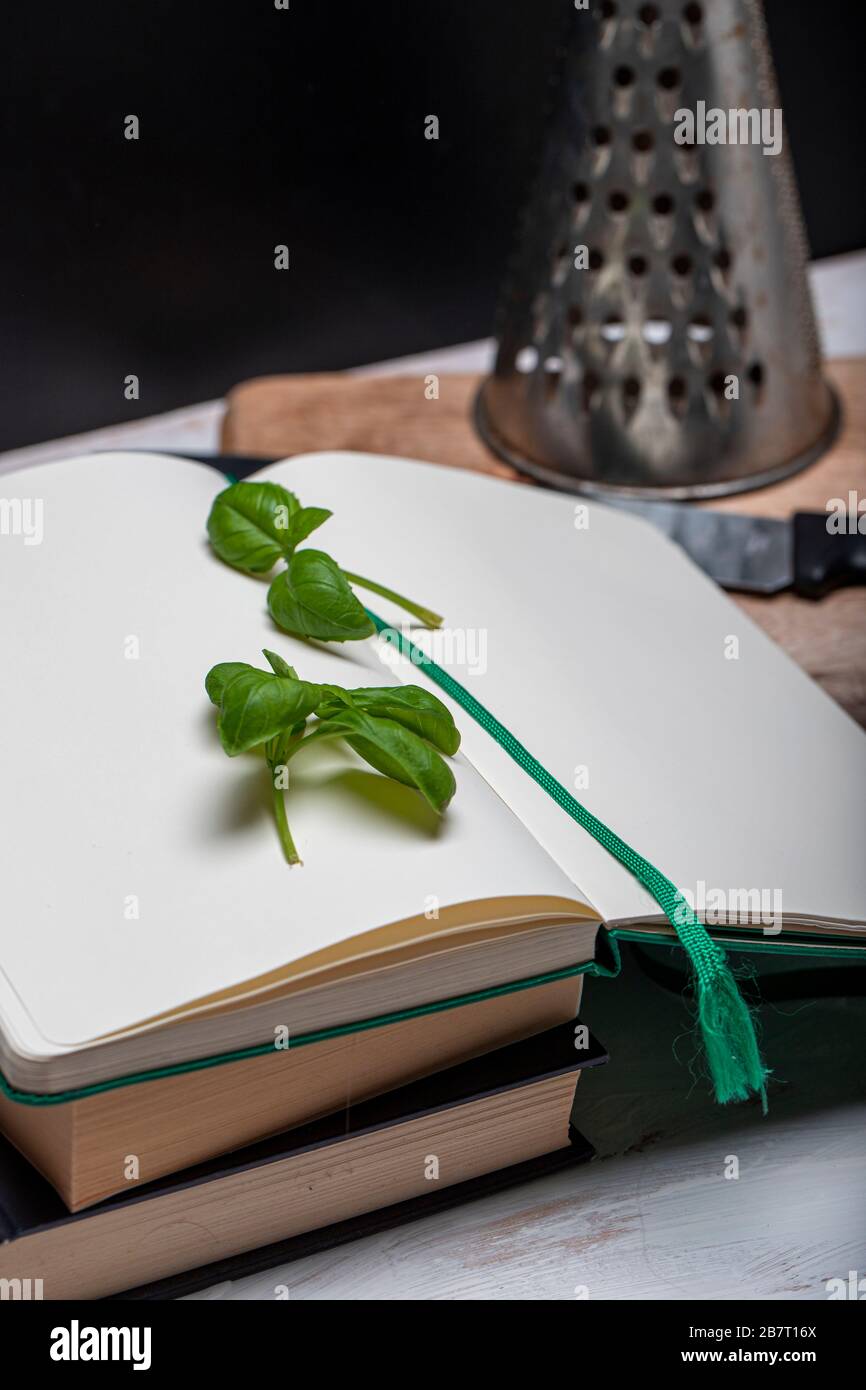 Basil leaveson a desk with a notebook for recipes and notes a composition with negative space a background for advertsing Stock Photo