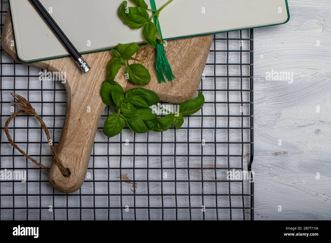 Basil leaveson a desk with a notebook for recipes and notes a composition with negative space a background for advertsing Stock Photo