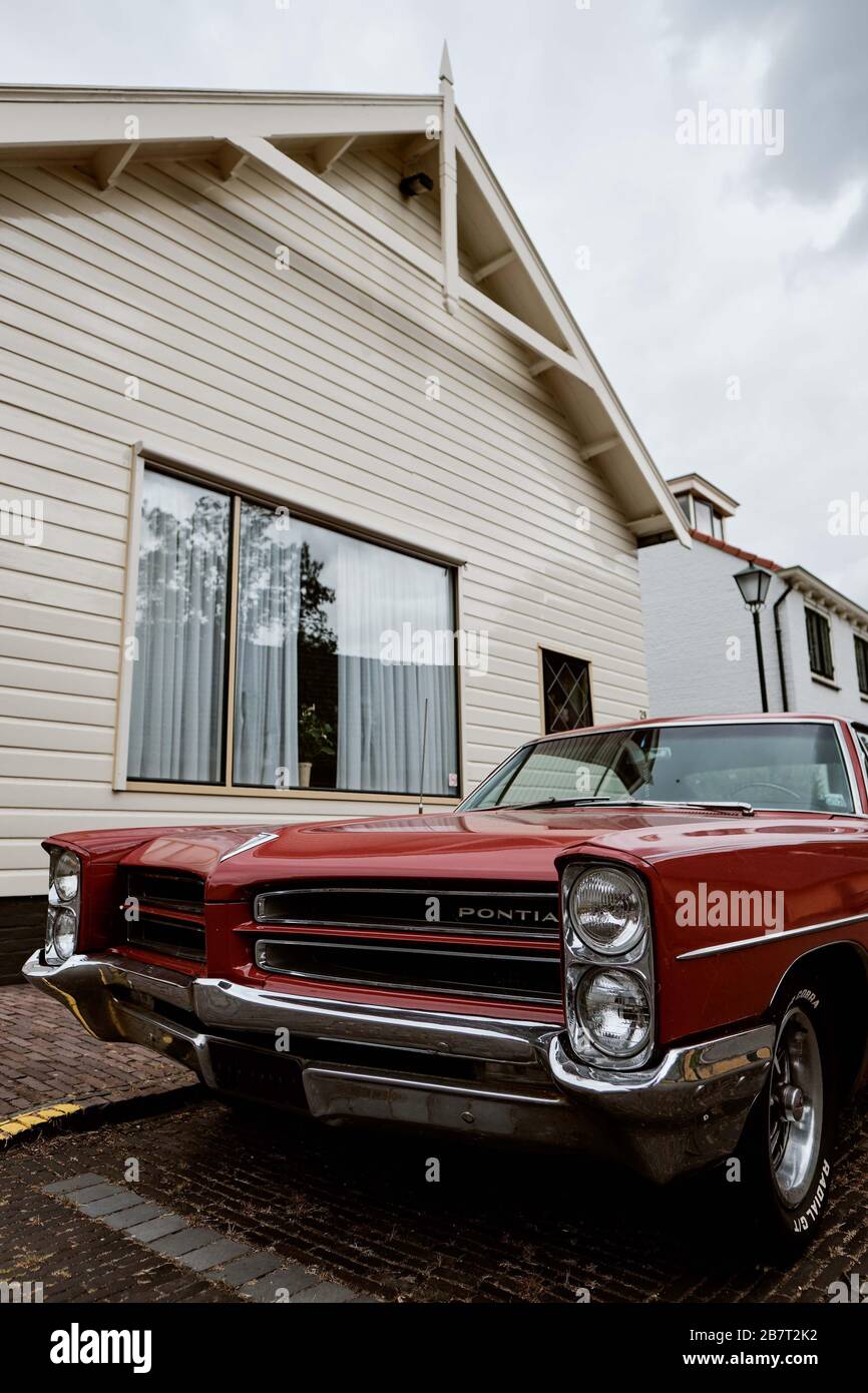 Naarden, The Netherlands - July 7 2019: 1966 Pontiac Parisienne red, view of the Pontiac logo Stock Photo
