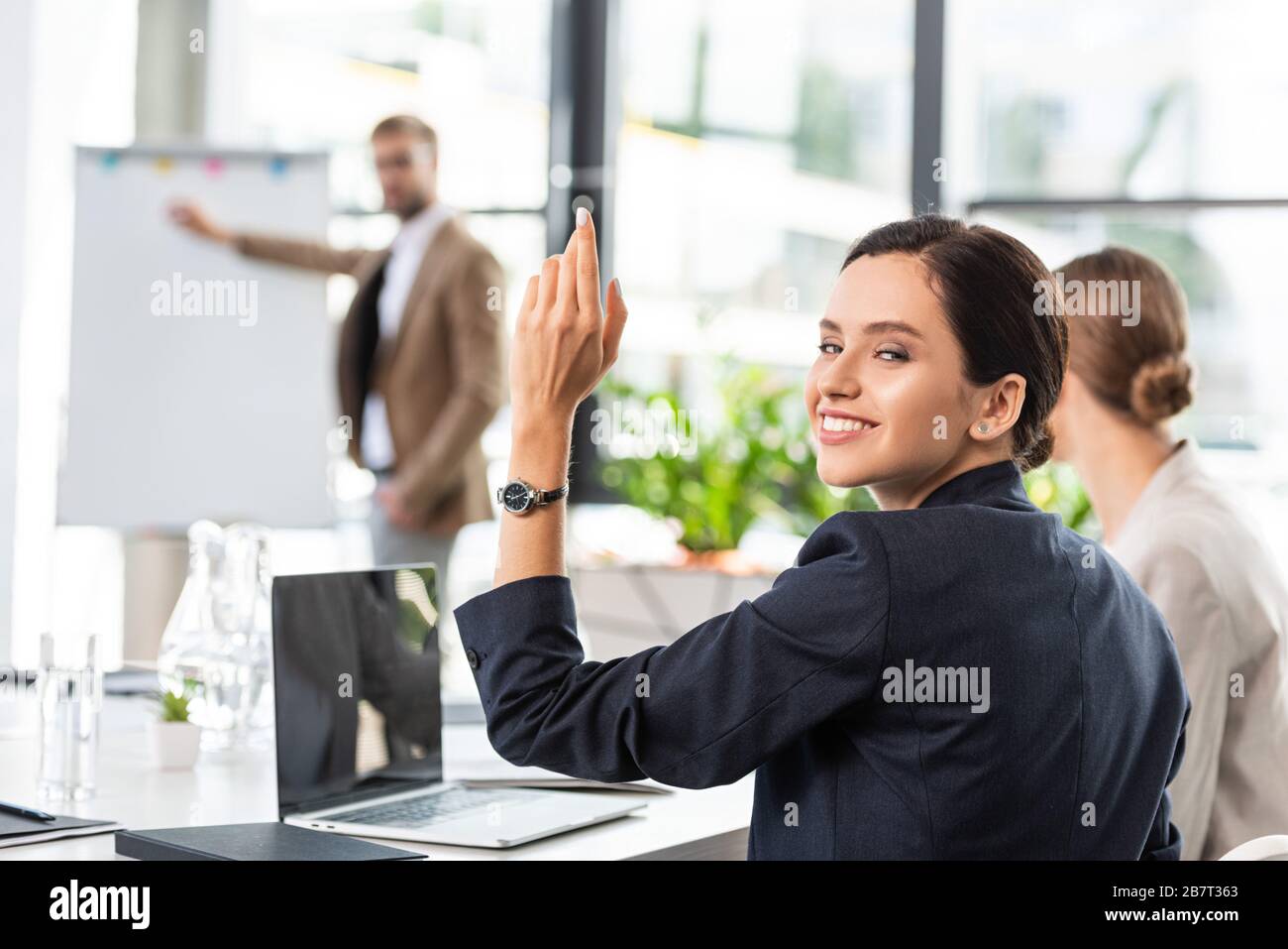 Businesswoman raising hand hi-res stock photography and images - Alamy