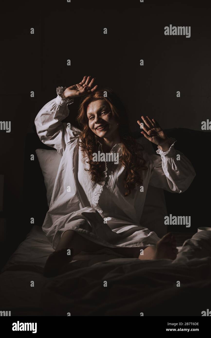 terrible obsessed smiling girl in nightgown sitting in bed Stock Photo ...