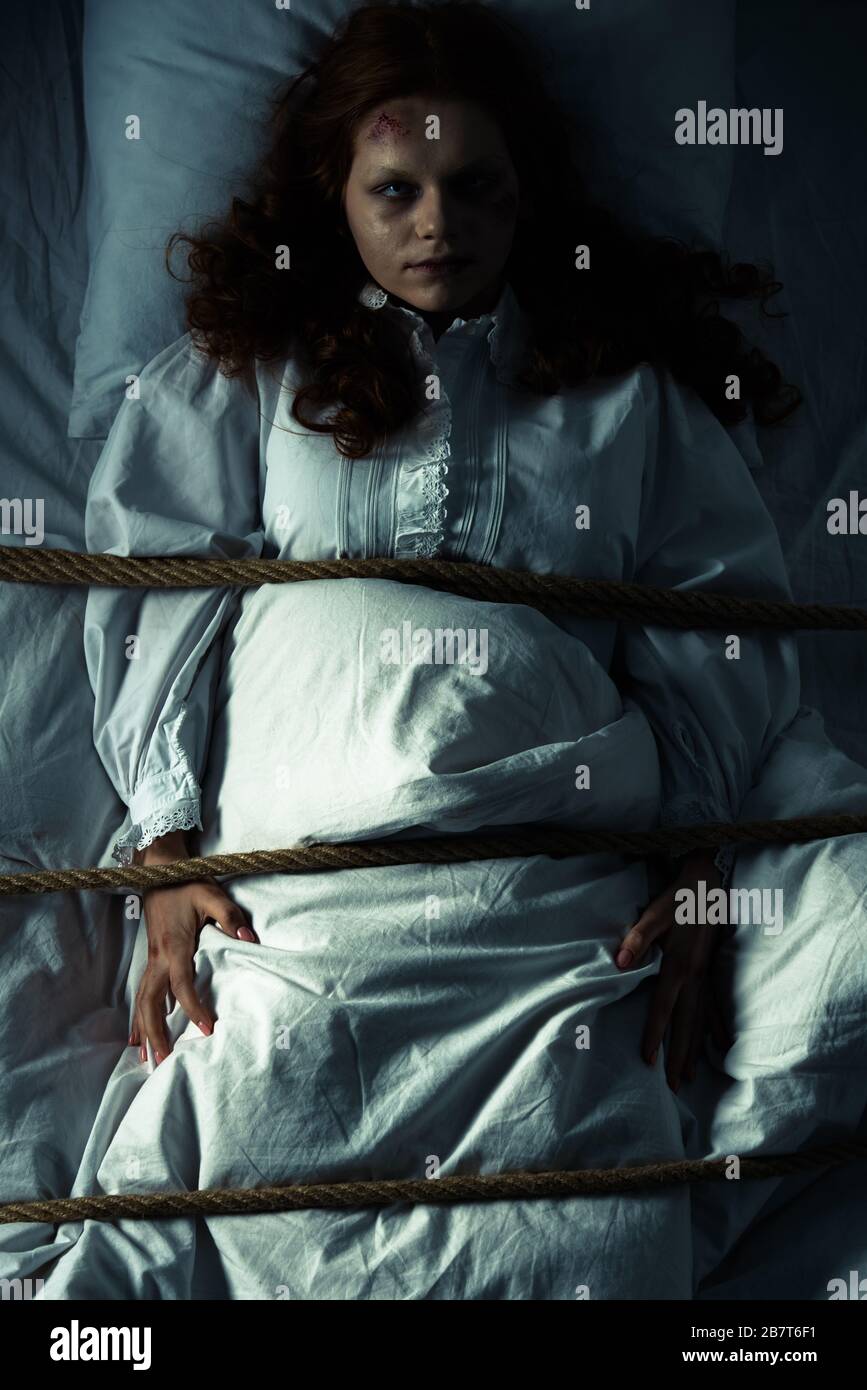 obsessed woman in nightgown bound with rope in bed Stock Photo Alamy